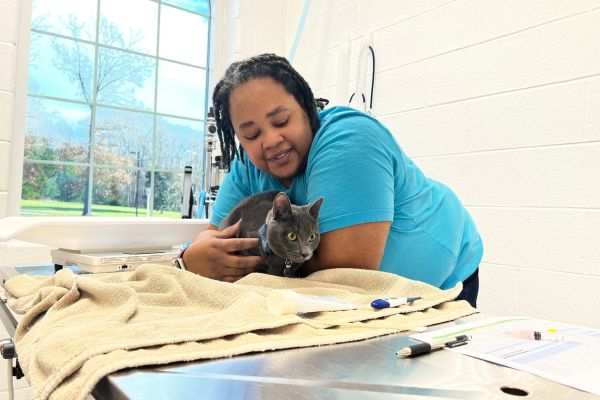 Technician Vivian holding a cat.